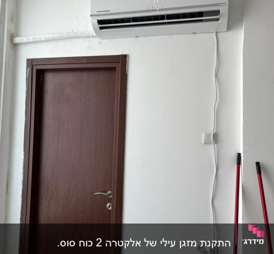 מזגן מותקן על קיר מעל דלת חומה